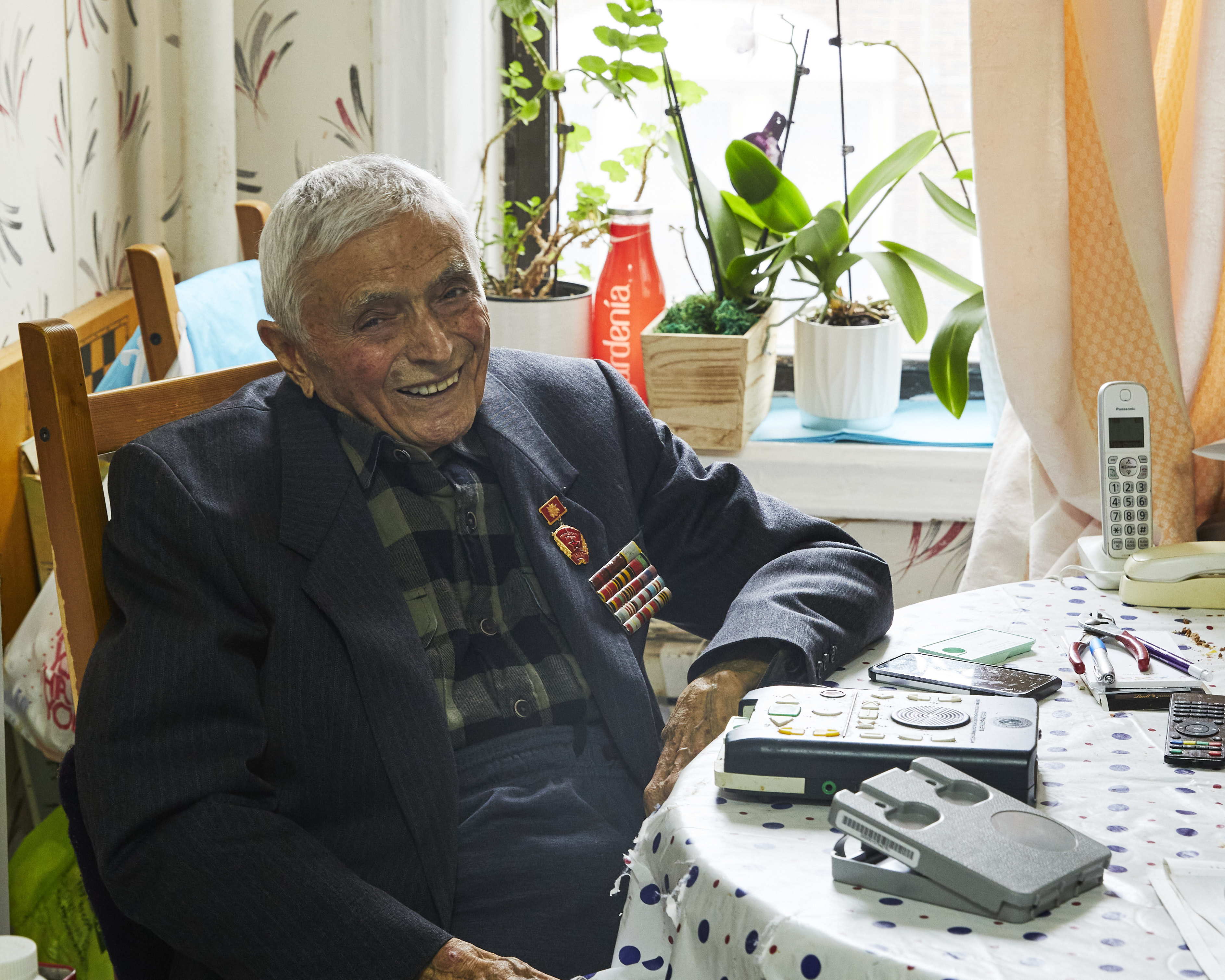 Image: A JBI Patron, sitting at a table and smiling